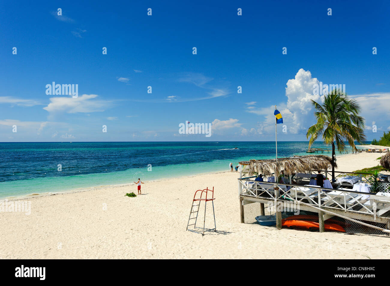 Taino, Freeport, Bahamas, Grand Bahama Island beach, einen Mann auf einem weißen Sandstrand vor der Terrasse einer Restaurant-Verkleidung Stockfoto
