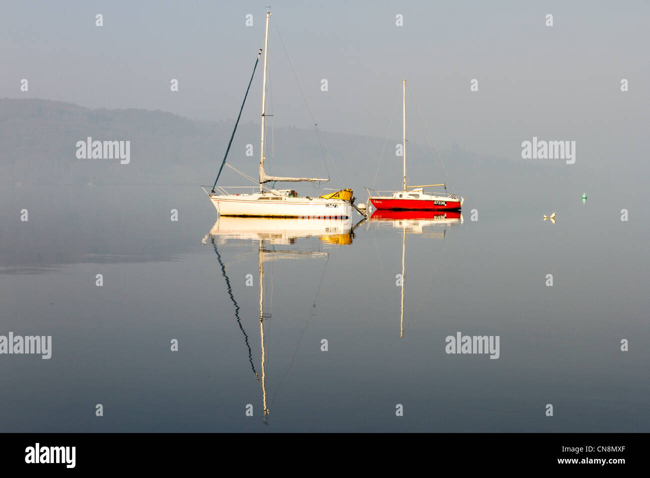 Boote am Lake Windermere eine Feder ruhigen Abend mit saisonabhängige im Hintergrund Stockfoto