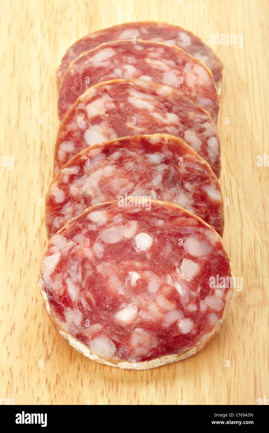 Salami in Scheiben geschnitten auf Holzbrett Stockfoto