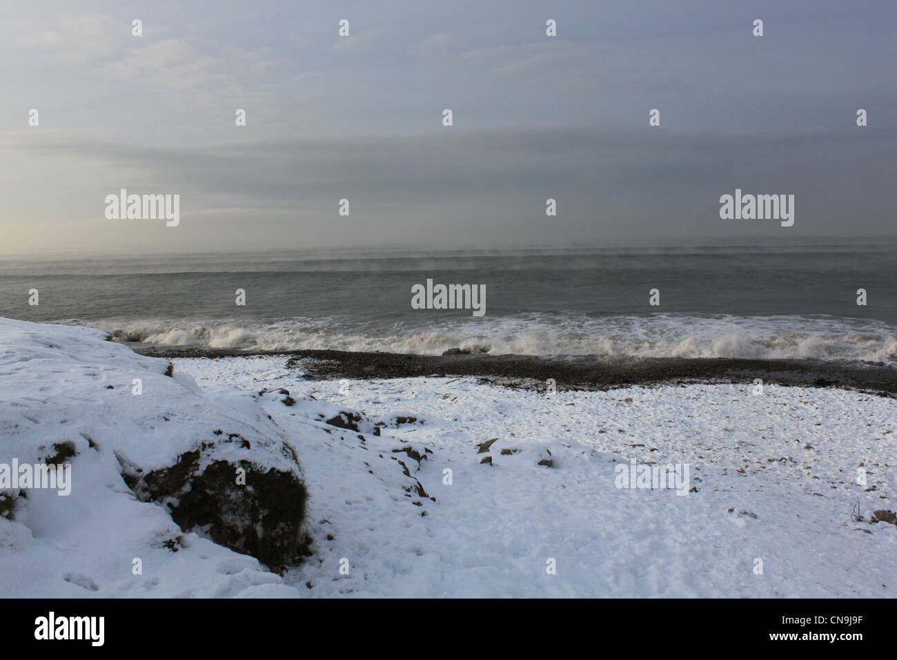 raue See mit Schnee am Strand Stockfoto