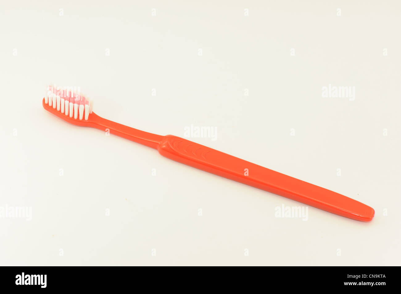 Zahnbürste hell gefärbt auf weißem Hintergrund fotografiert Stockfoto