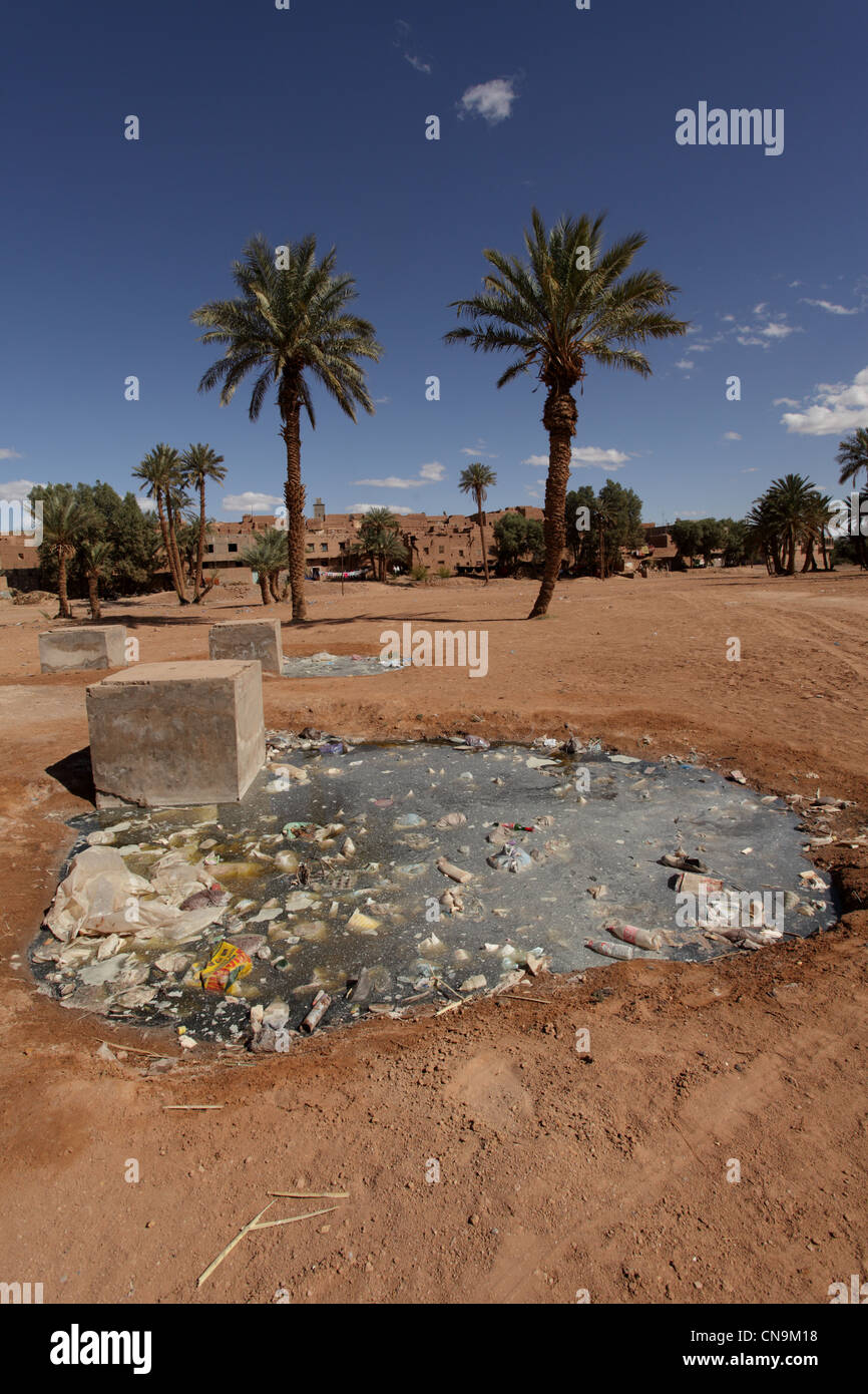 Verschmutztes Wasser Loch außerhalb eines kleinen Dorfes in der Draa-Tal, Südmarokko, Afrika Stockfoto