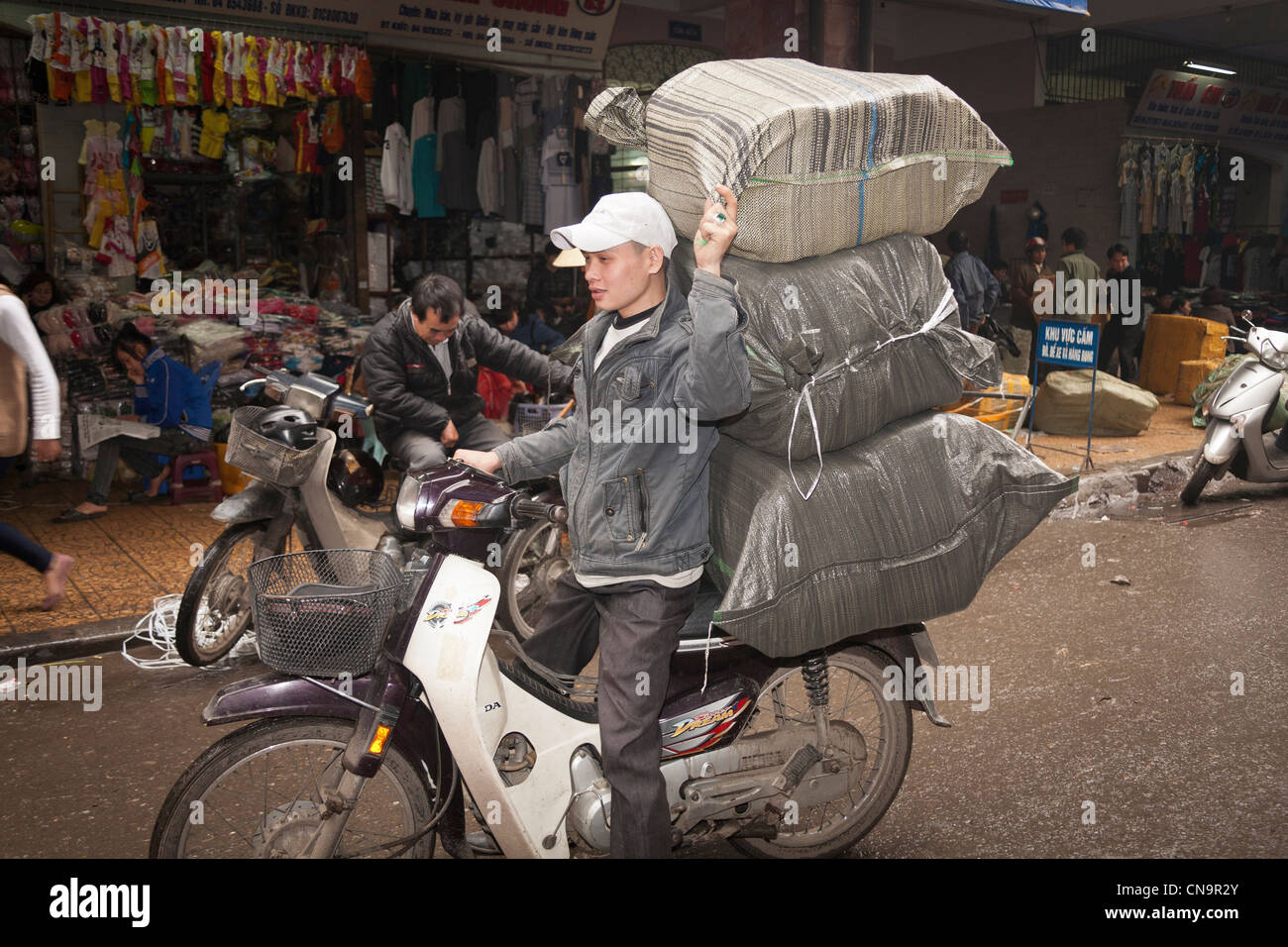Mann, die Transport von großen Belastung des Rückens von seinem Motorrad in der Altstadt, Hanoi, Vietnam Stockfoto