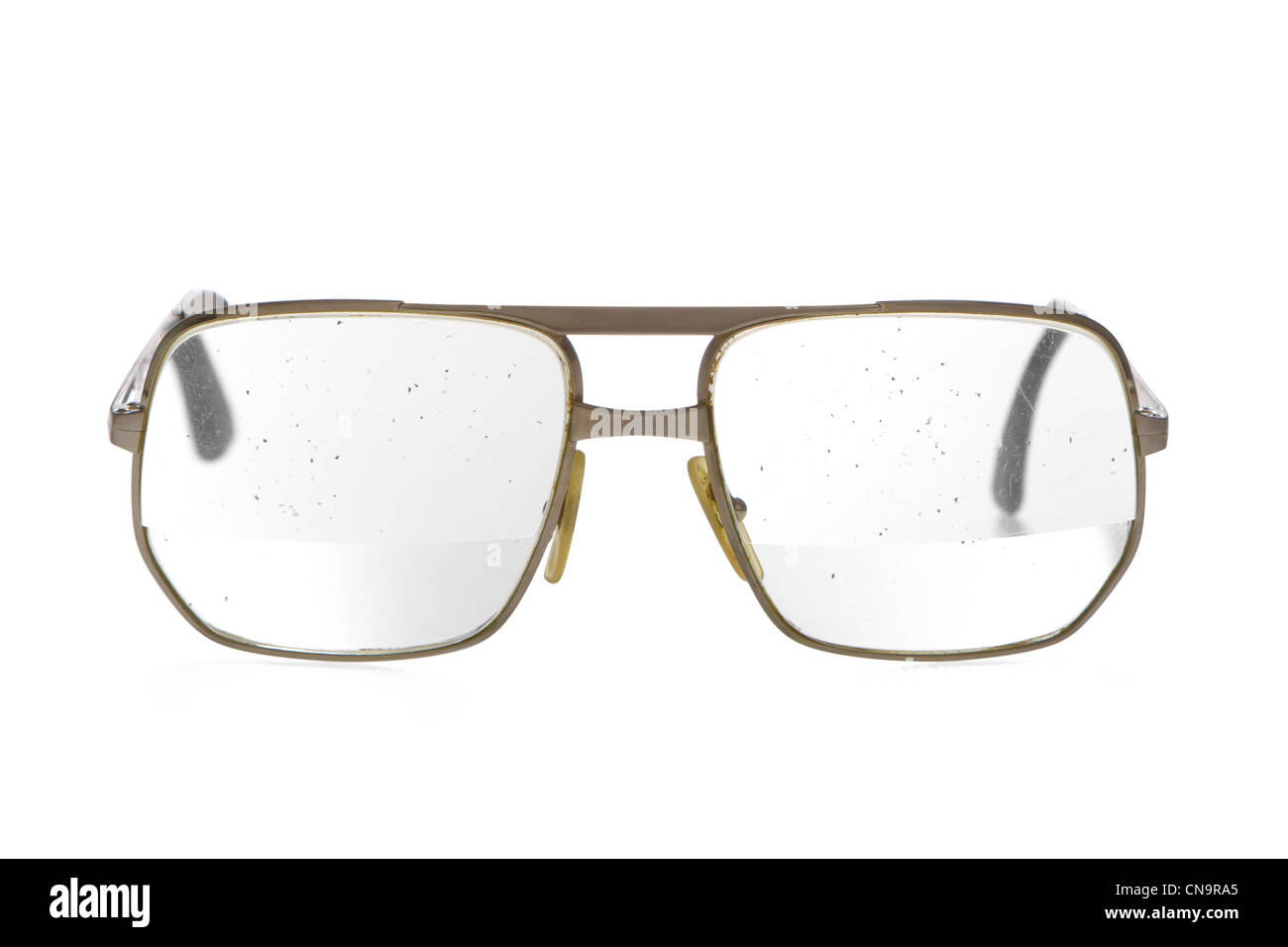 Sehr alt, schmutzig, klapprigen Brillen mit dicken Bifokallinse in gold Metallrahmen. Brille des älteren Menschen. Gesprenkelte Schmutz auf der Linse. Stockfoto
