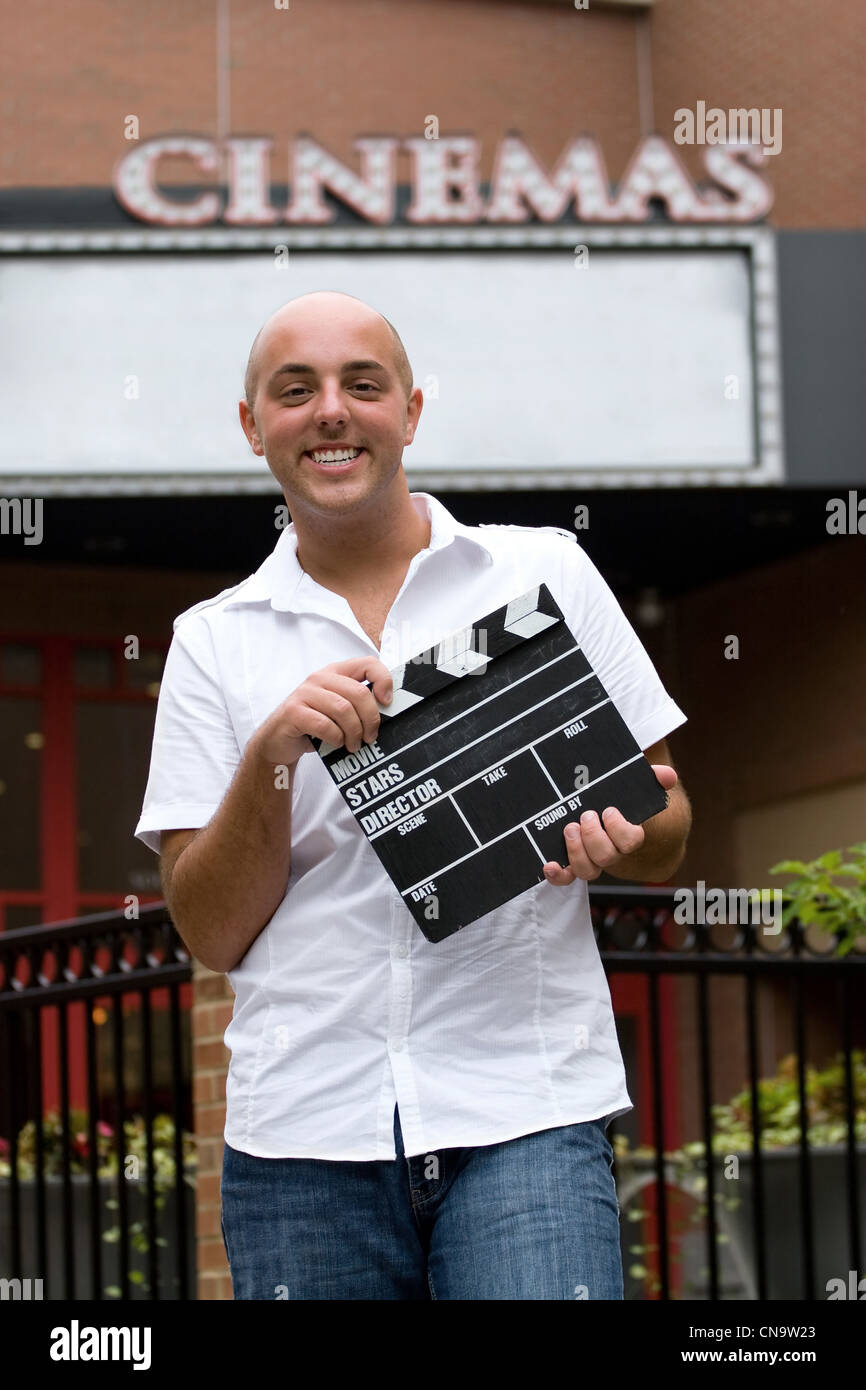 Ein junger Mann oder Filmkritiker halten Clap-Vorstand einen Film vor den Kinos. Stockfoto