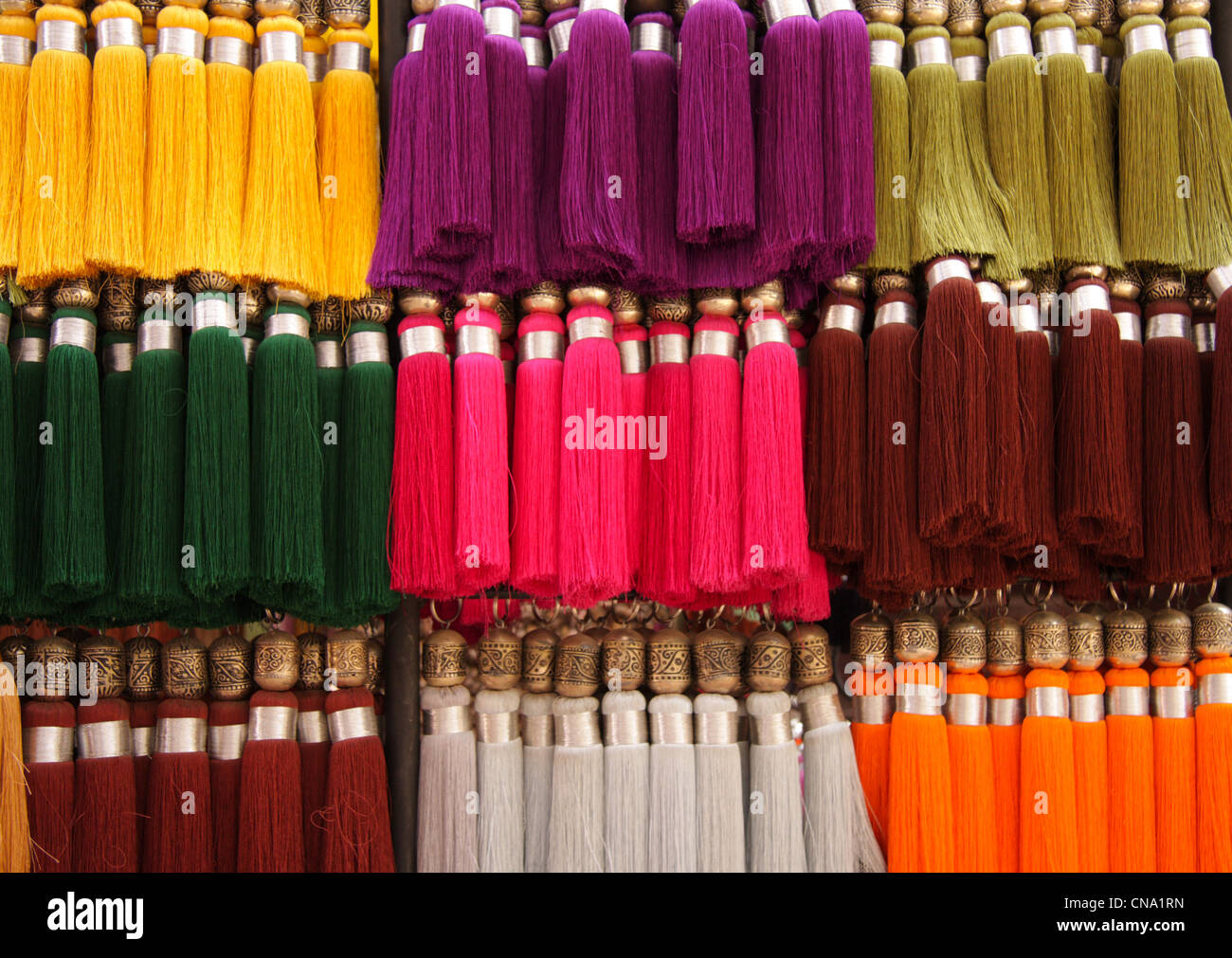 Seidene Fäden/Quasten hängen zum Verkauf in einem Kurzwaren Souk, Marrakesch, Marokko, Nordafrika Stockfoto