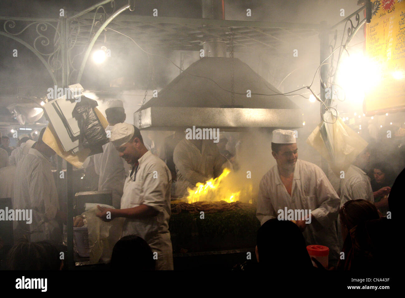 Köche Grillen über offenem Feuer am Grill Essen bei Einbruch der Dunkelheit in Place Djemaa el Fna, Marrakesch, Marokko, Nord; Afrika Stockfoto