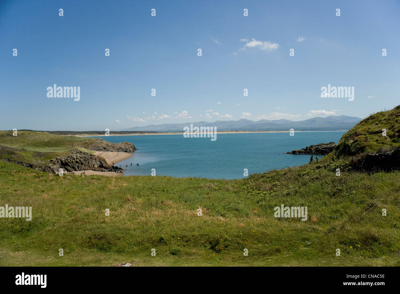 Strand auf der Insel Llanddwyn auf Anglesey Woth Newborough Wald und Hügel des Snowdonia in der Ferne Stockfoto