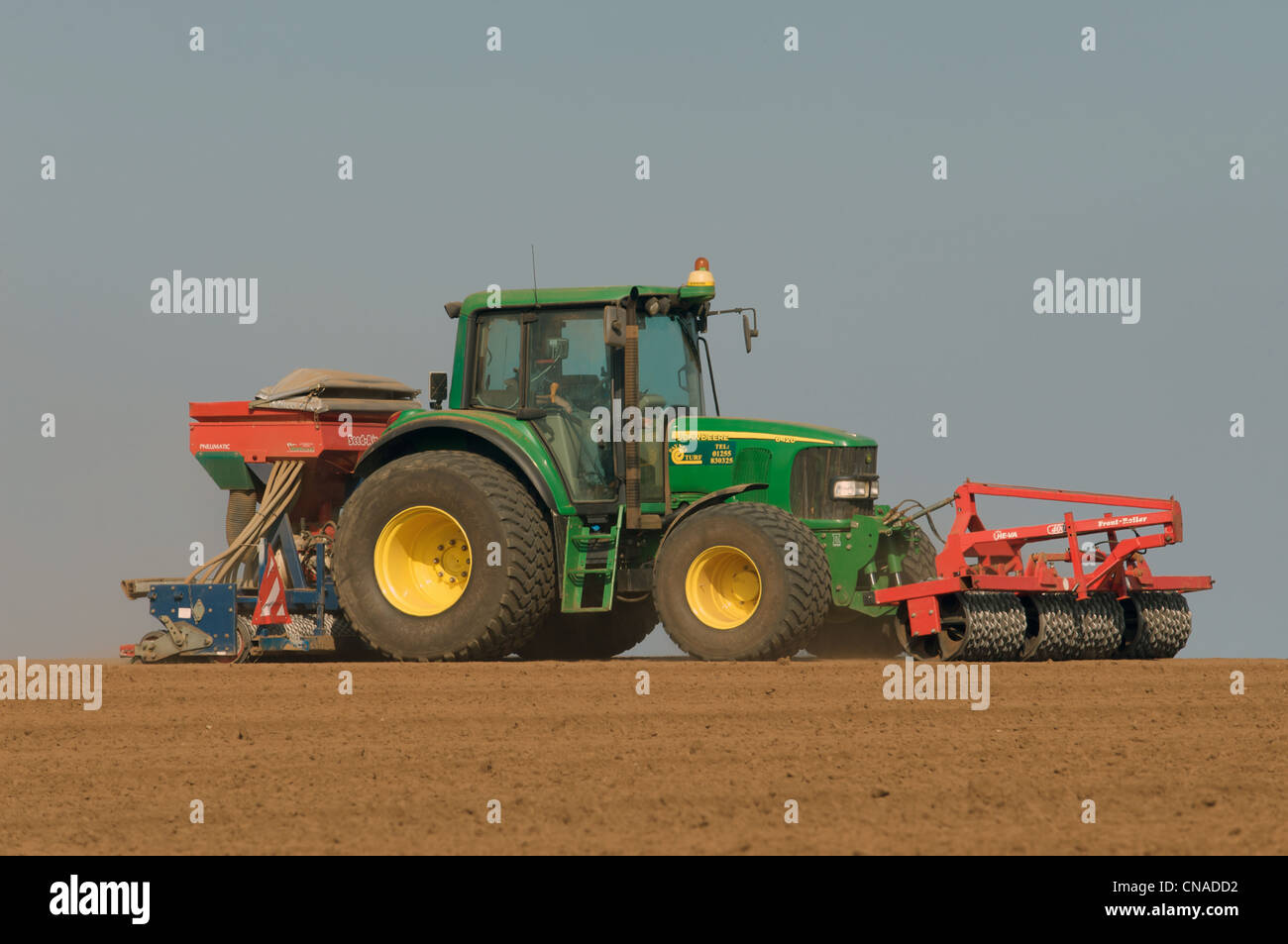 Traktor ausgestattet mit Frontrolle und Saatgut-Luft-Bohrer auf Dürre betroffenen Land in Suffolk England Stockfoto