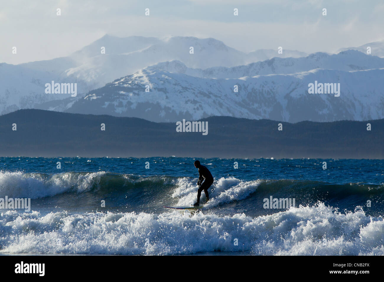 Surfen an der Küste im Winter mit im Hintergrund, Eagle Beach, südöstlichen Alaska Chilkat Mann Stockfoto
