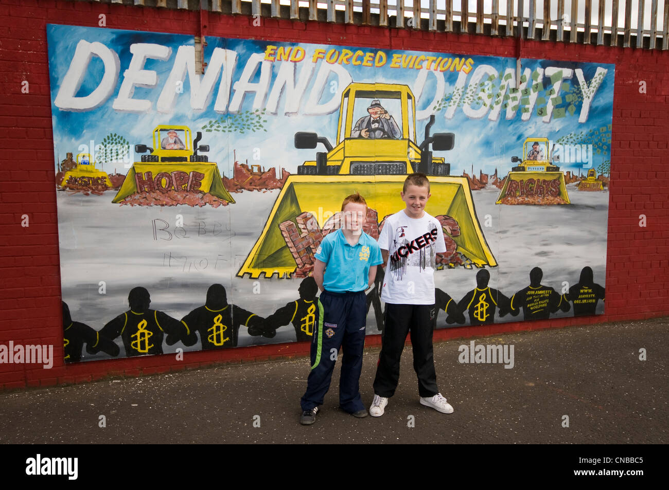 Großbritannien, Nordirland, Belfast, katholischen westlichen Bezirk fällt, zwei jungen vor einem Wandbild Stockfoto