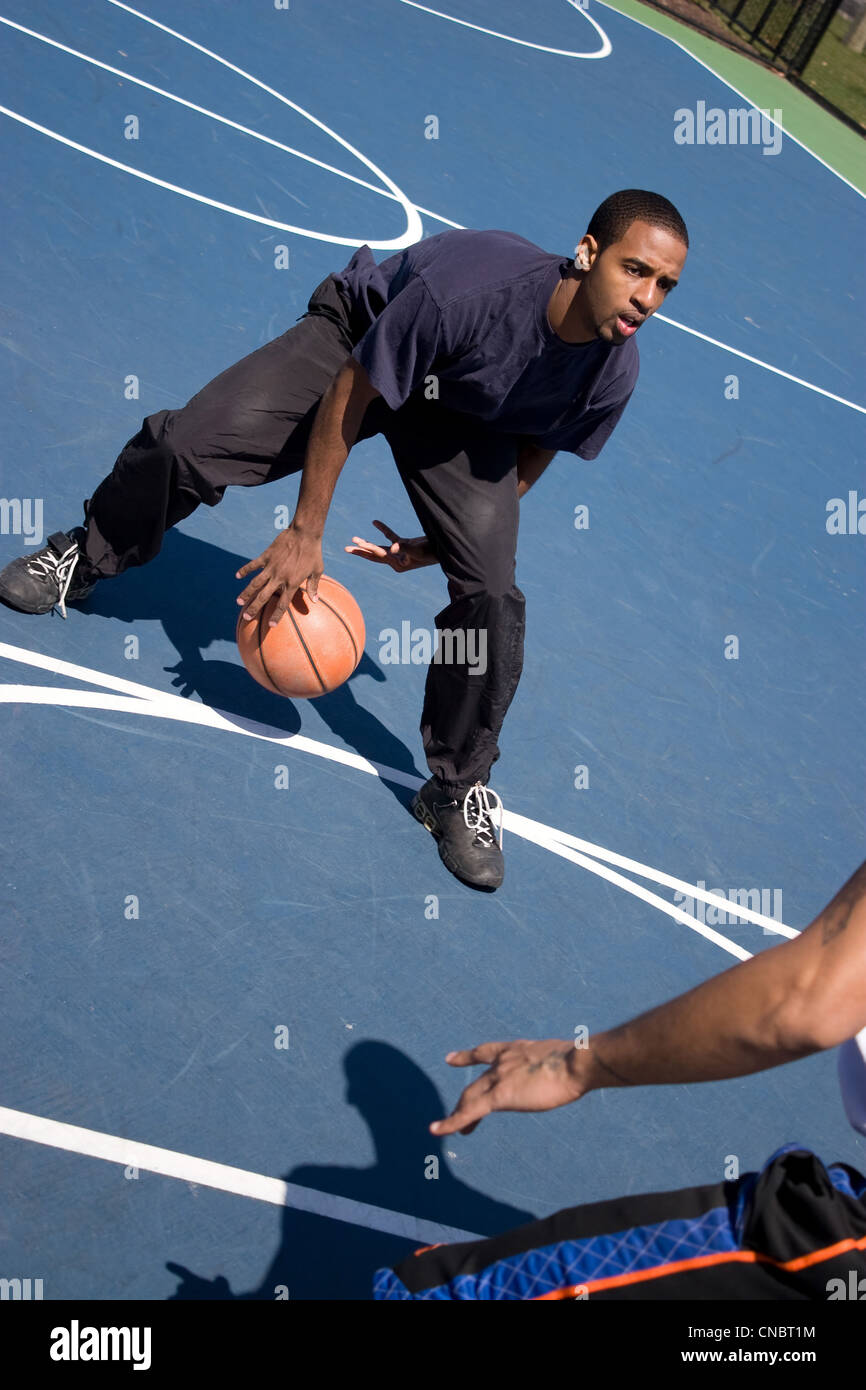 Eine junger Basketballspieler Beiträge gegen seinen Gegner bei einem auf einem Basketball-Spiel. Stockfoto