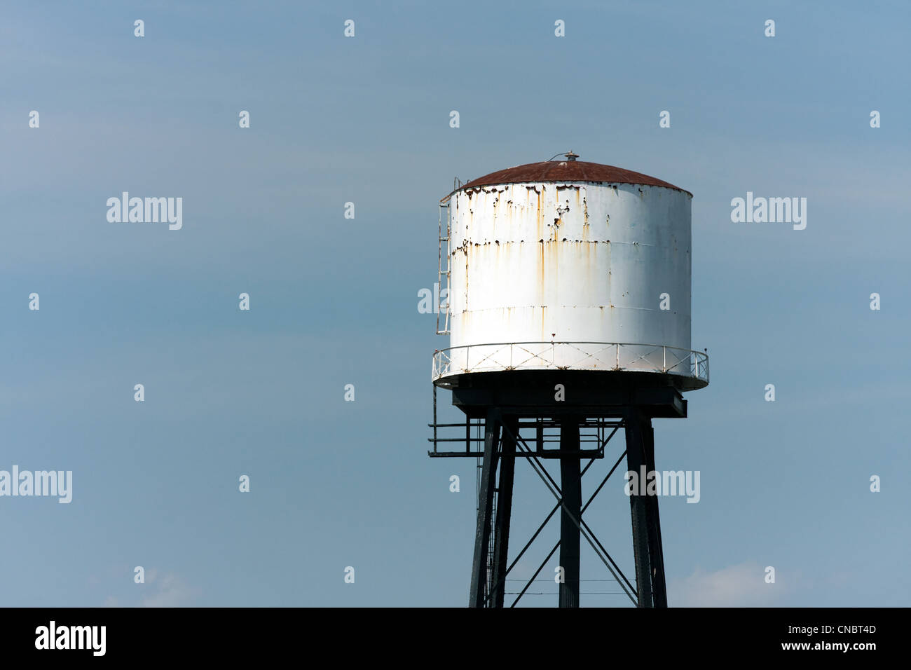 Eine alte verrostete Wasserturm isoliert über ein leerer blauer Himmel. Stockfoto