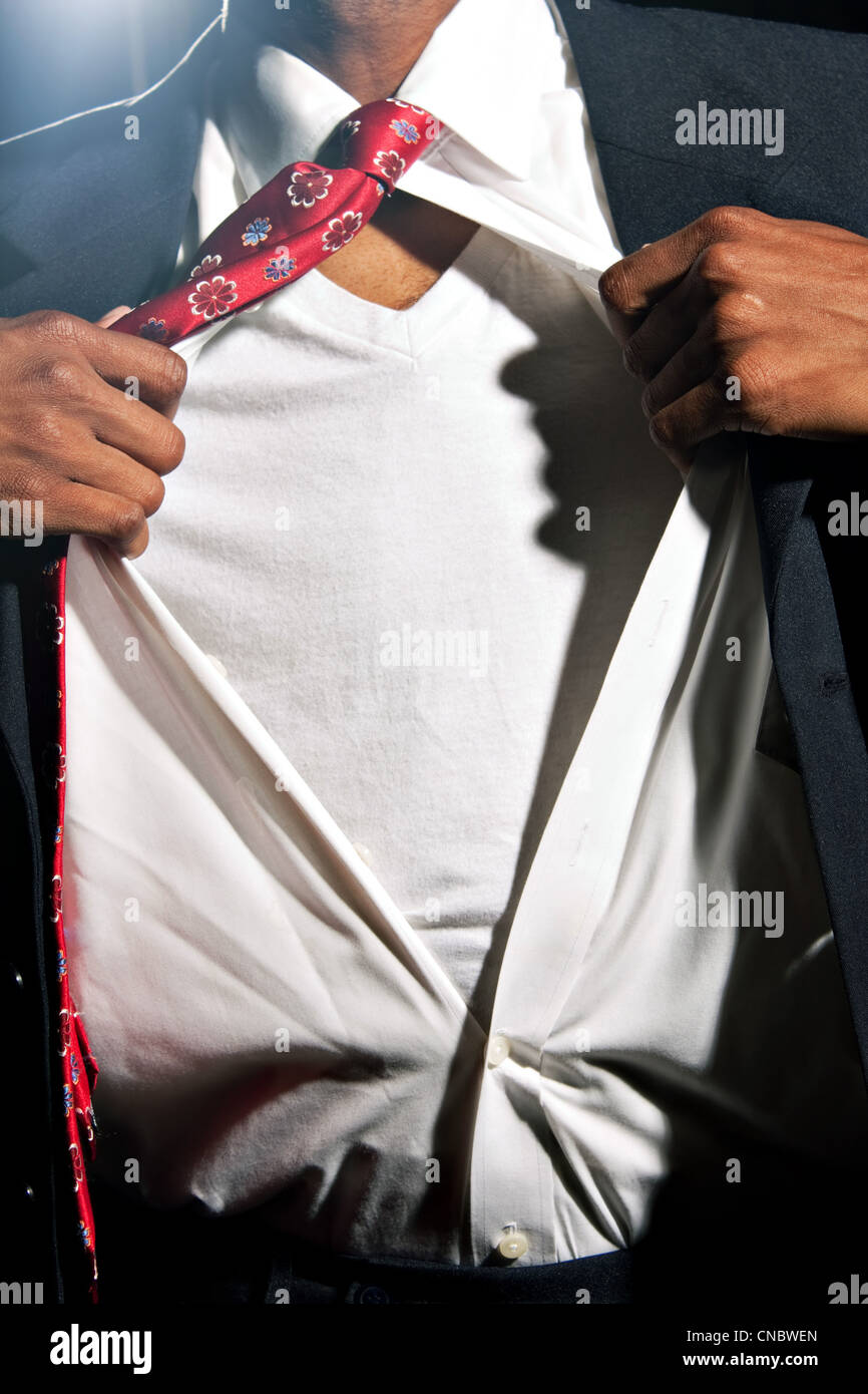 Ein afrikanischer amerikanischer Mann gekleidet in eine dunkle farbige Risse öffnen sein Kleid Hemd enthüllt das T-shirt darunter (mit Exemplar) Stockfoto