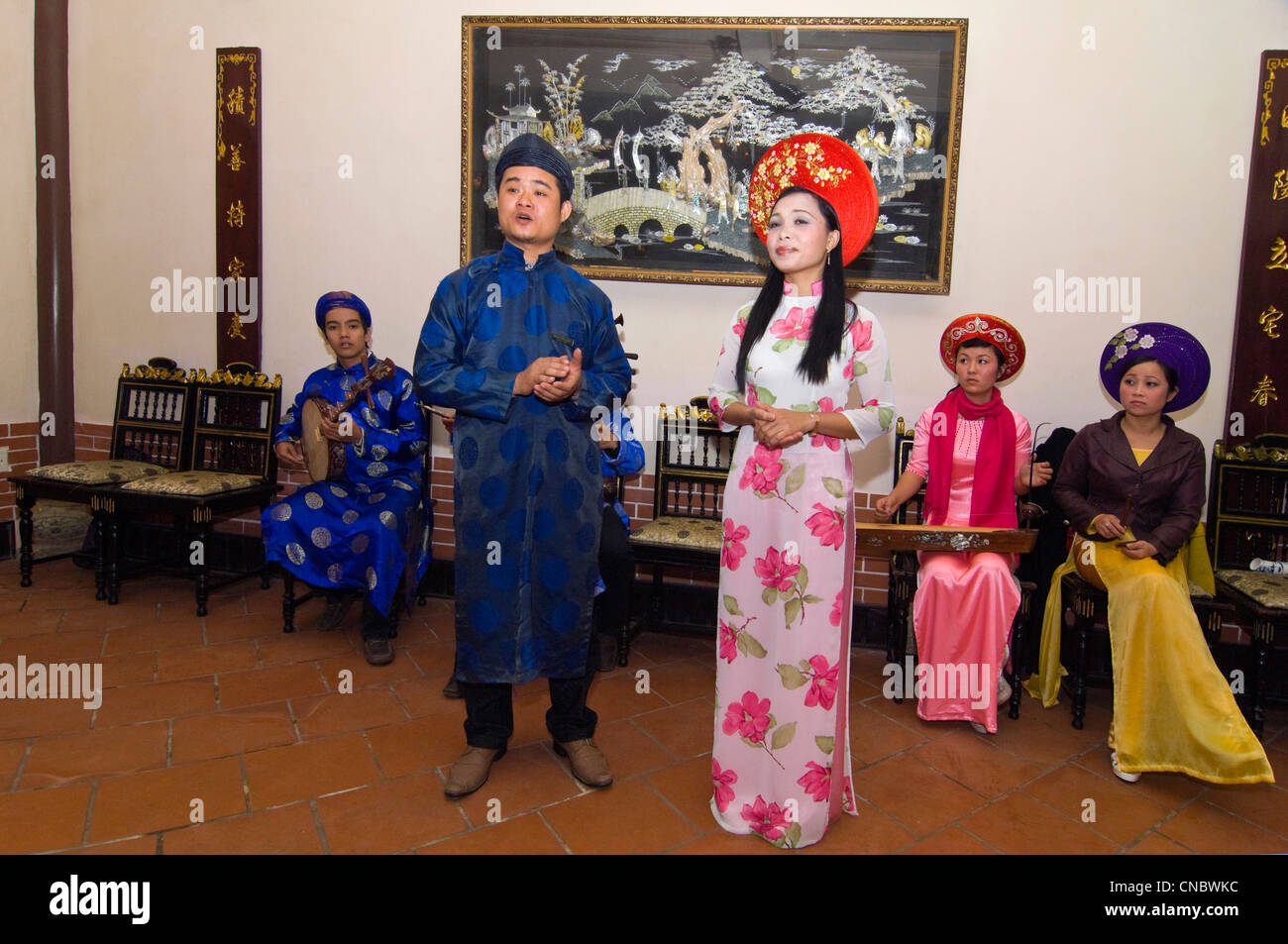 Horizontale Ansicht einer traditionellen vietnamesischen Truppe der Musiker spielen und singen traditionelle Volkslieder in Tracht. Stockfoto