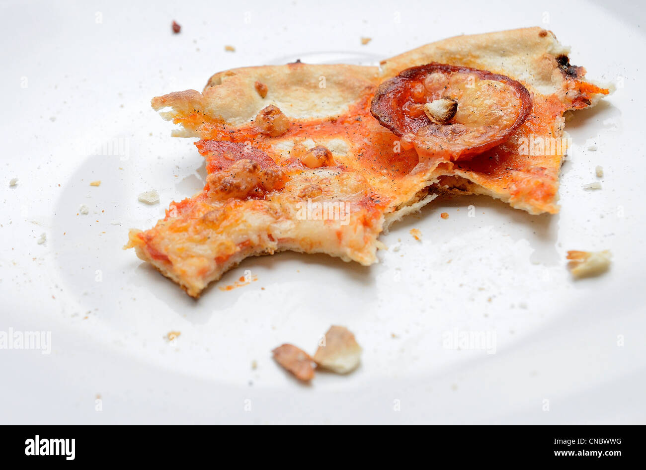 Die Überreste der Salami Pizza auf die weiße Schale. Stockfoto