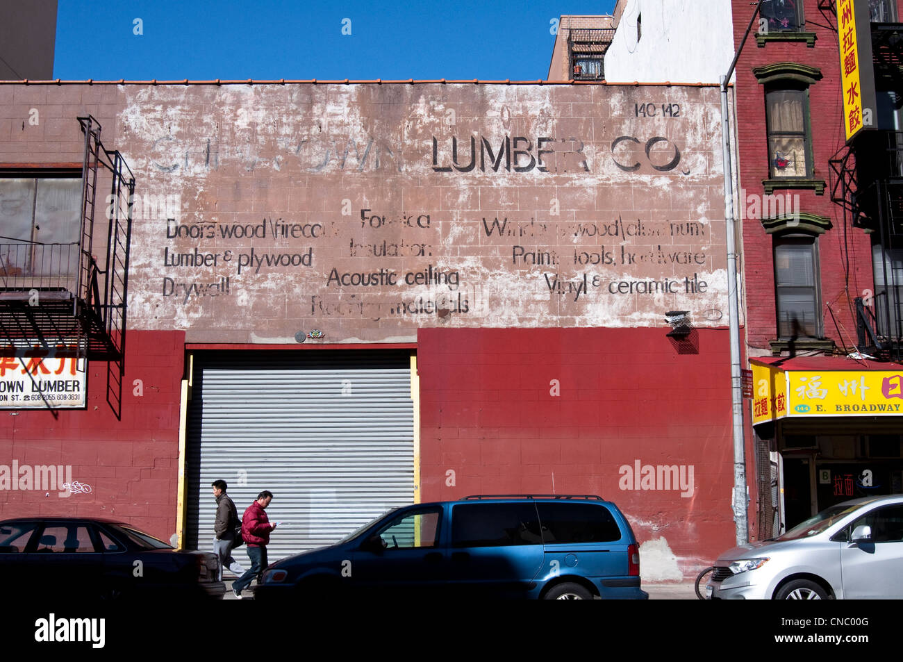 Ein alter Hase malte Werbung [Geist Zeichen] für Chinatown Lumber Co. am East Broadway in Chinatown, New York City, USA. Stockfoto