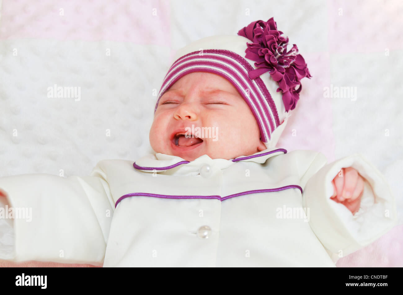 Neugeborenes Babymädchen weint im Schlafzimmer. Unglücklich Momment für sie. Stockfoto