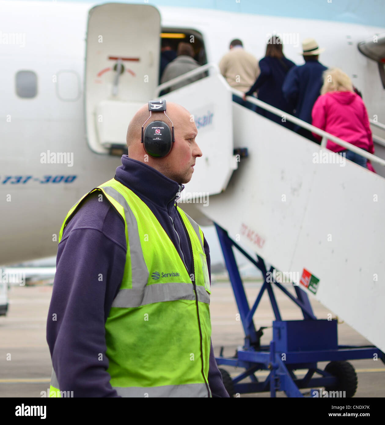 Servisair Bodenpersonal am Flughafen Birmingham International beobachten Fluggästen ein BMI Baby Boeing 737-300 Stockfoto