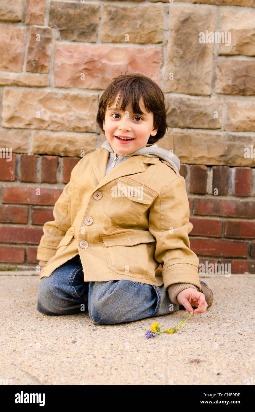 Ein 4-jähriger Junge mit Blumen Stockfoto