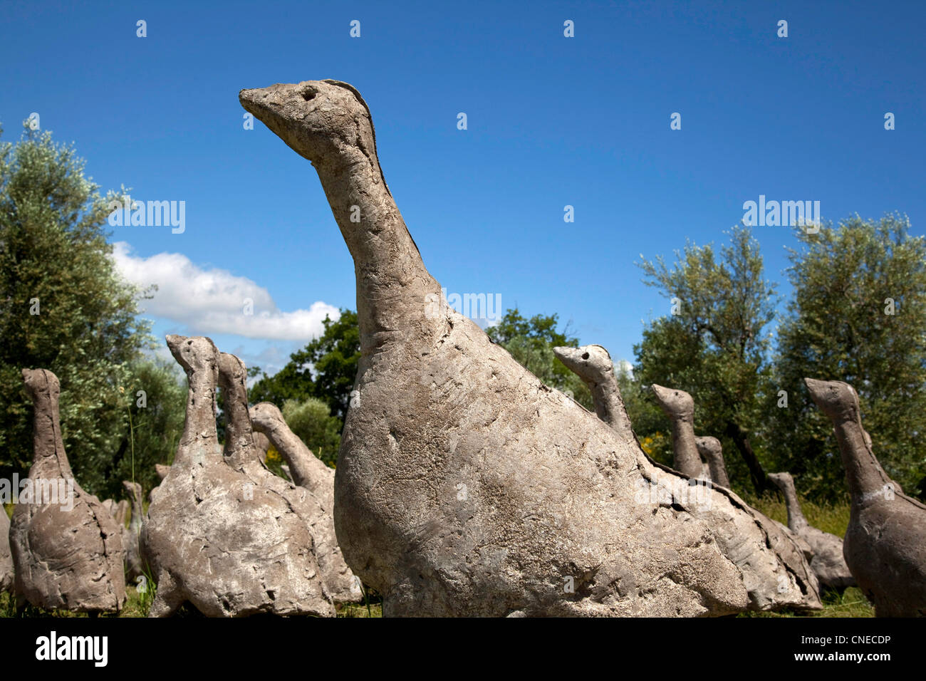 Eine Herde von Betongänsen des schweizer Bildhauers Olivier Estoppey Scheinen über ein Feld beim Daniel Spoerri zu gehen Skulpturengarten Stockfoto