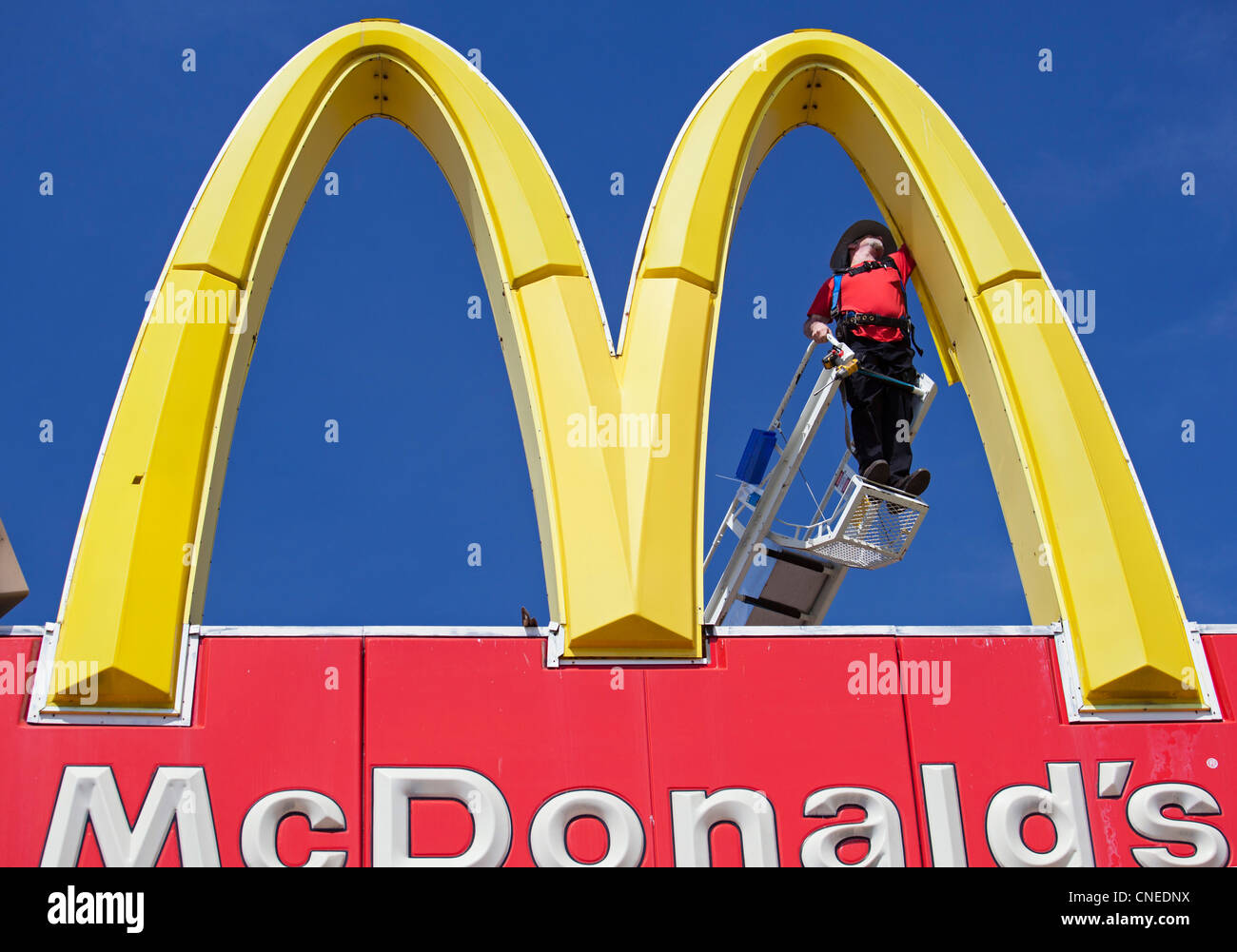 Detroit, Michigan - ein Arbeiter Reparaturen ein McDonalds "Golden Arches" Zeichen. Stockfoto