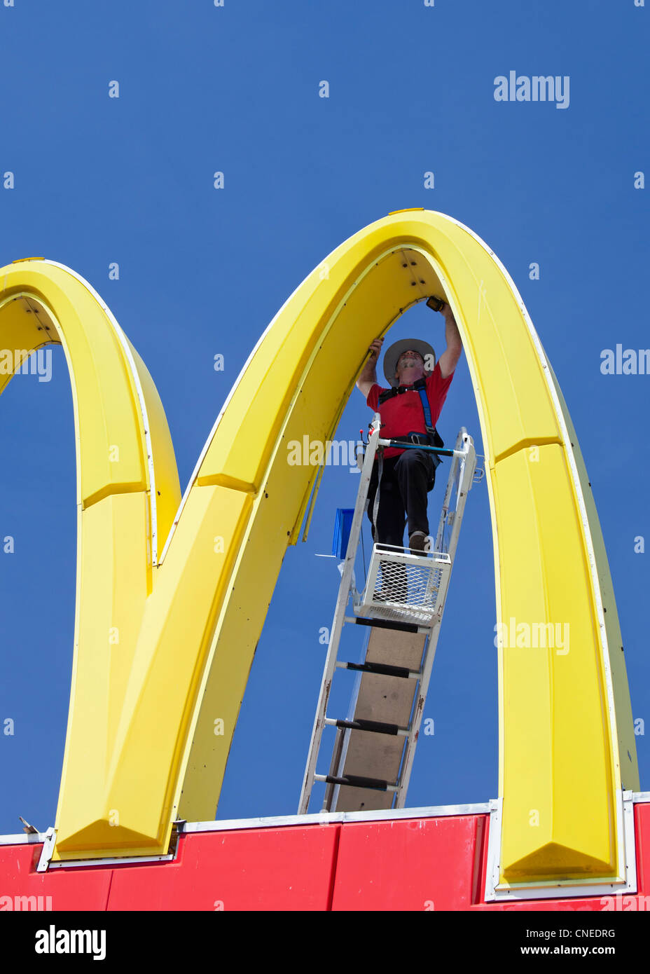 Detroit, Michigan - ein Arbeiter Reparaturen ein McDonalds "Golden Arches" Zeichen. Stockfoto