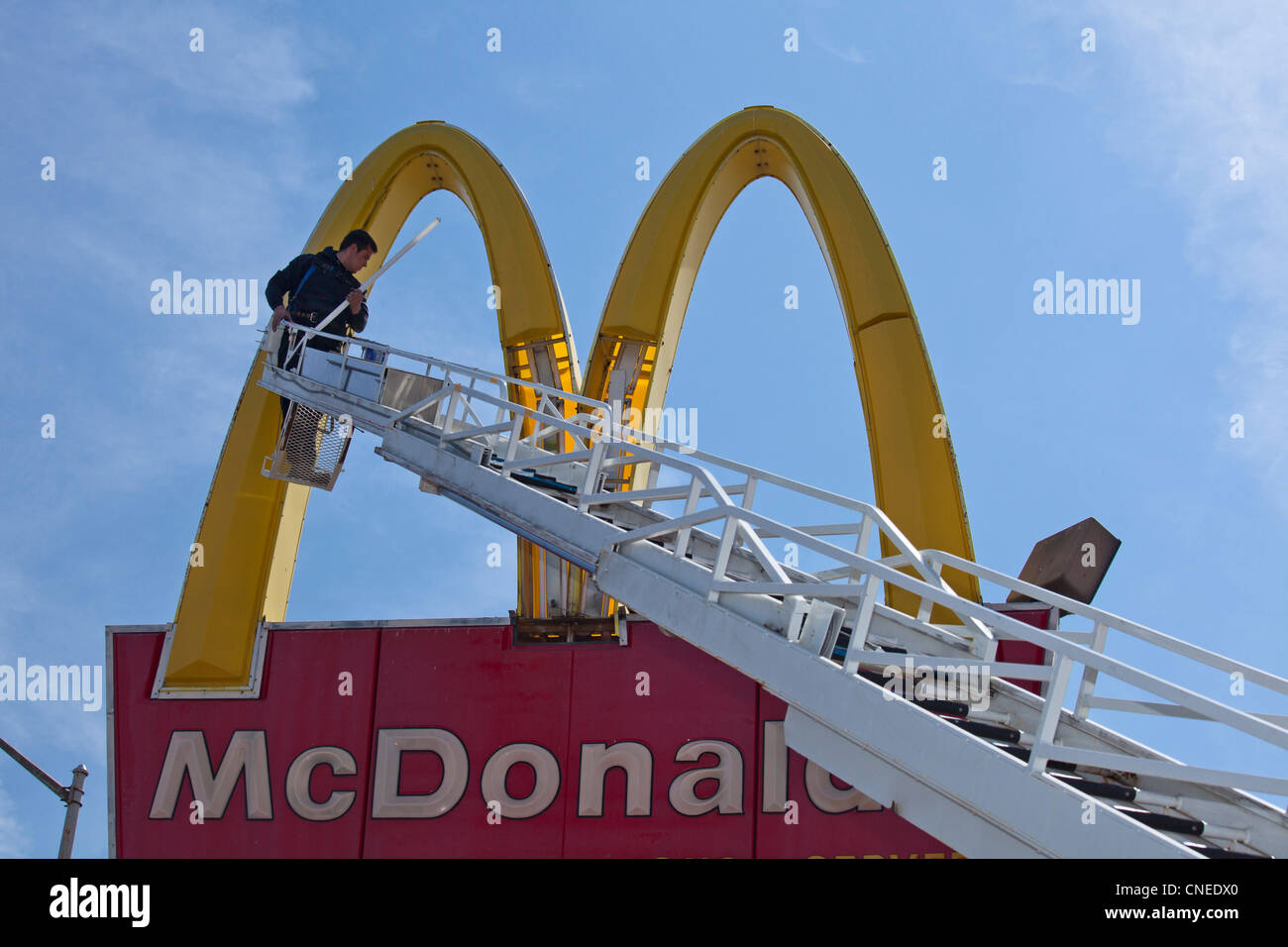 Detroit, Michigan - ein Arbeiter ersetzt Leuchtstoffröhren in McDonalds "Golden Arches" Zeichen. Stockfoto