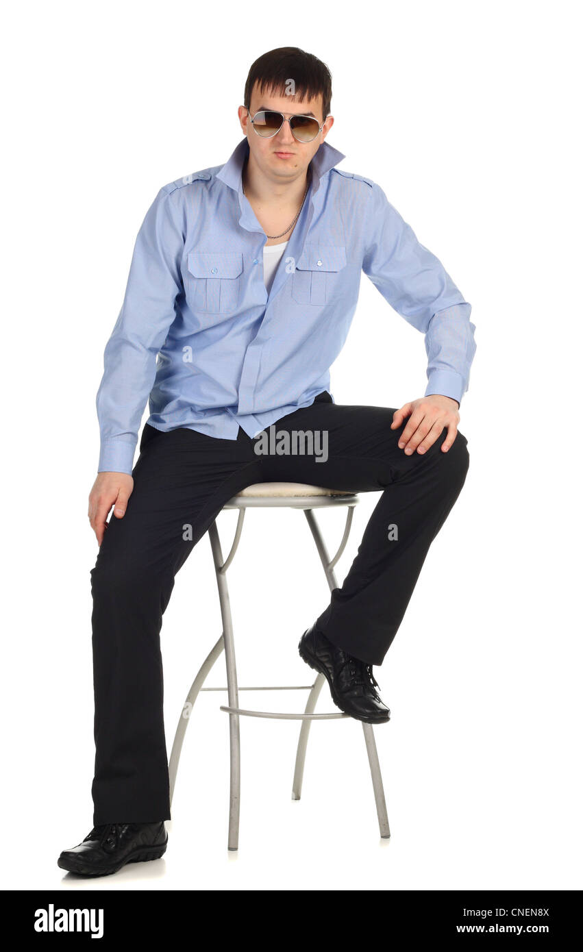 Lustiger Kerl sitzt auf dem Stuhl, auf dem weißen isoliert Stockfoto