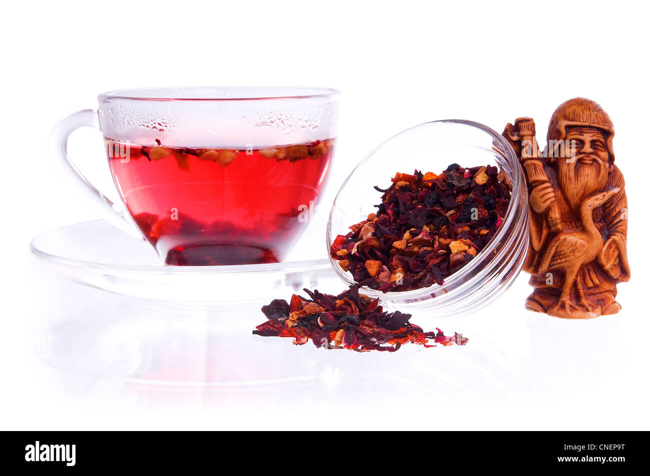 Gesundes Obst Tee in eine transparente Schale und Untertassen mit trockenen Früchtetee und Idol Wohlstand Statuette Stockfoto