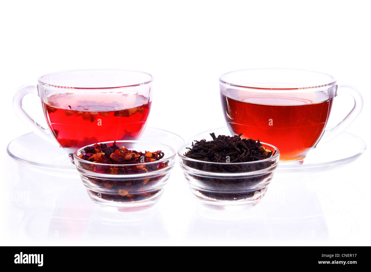 Zwei transparente Tassen und Untertassen mit flüssigen und trockenen schwarz und Früchte Tee Stockfoto