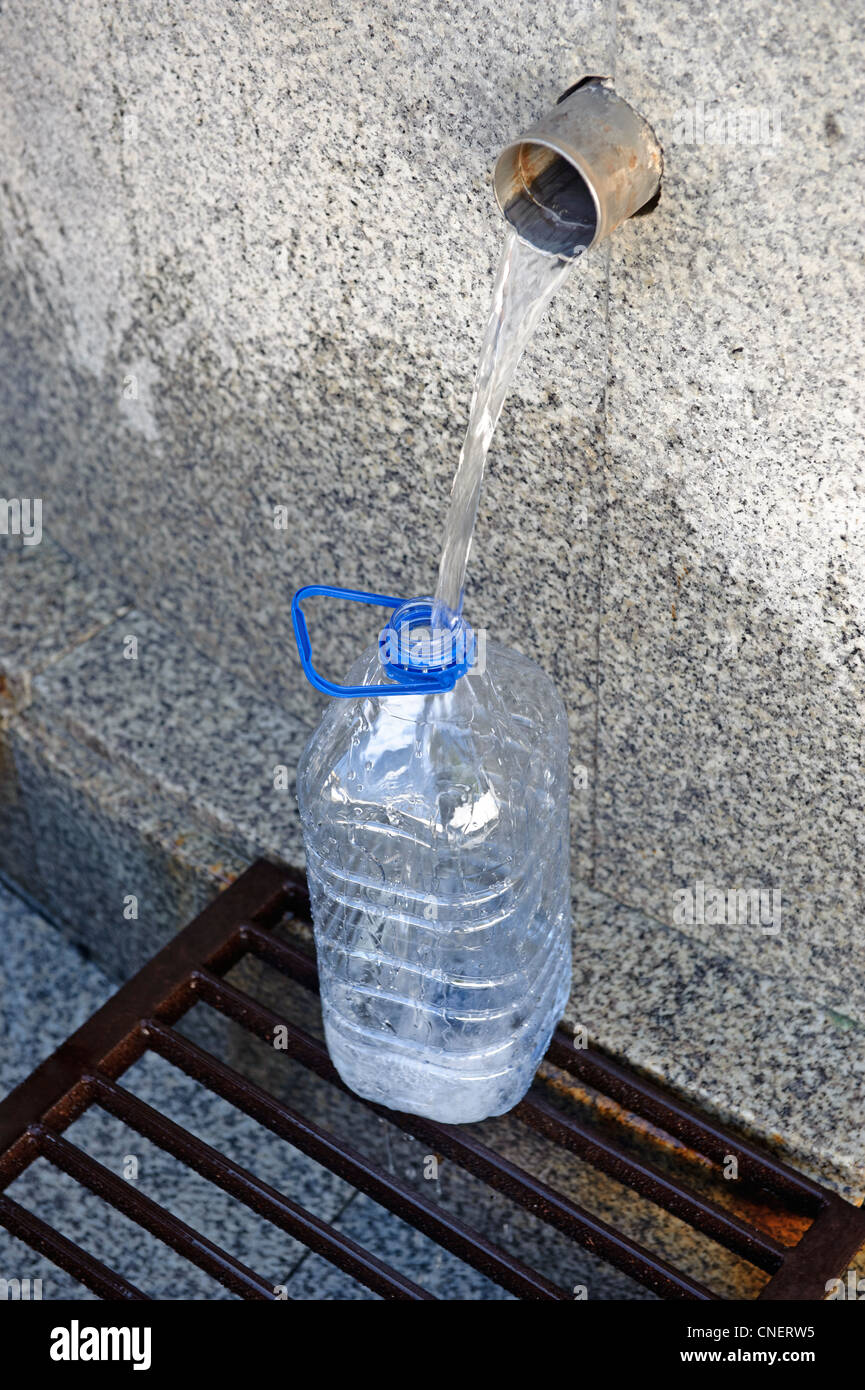 Wasserkrug, an einem öffentlichen Brunnen gefüllt Stockfoto