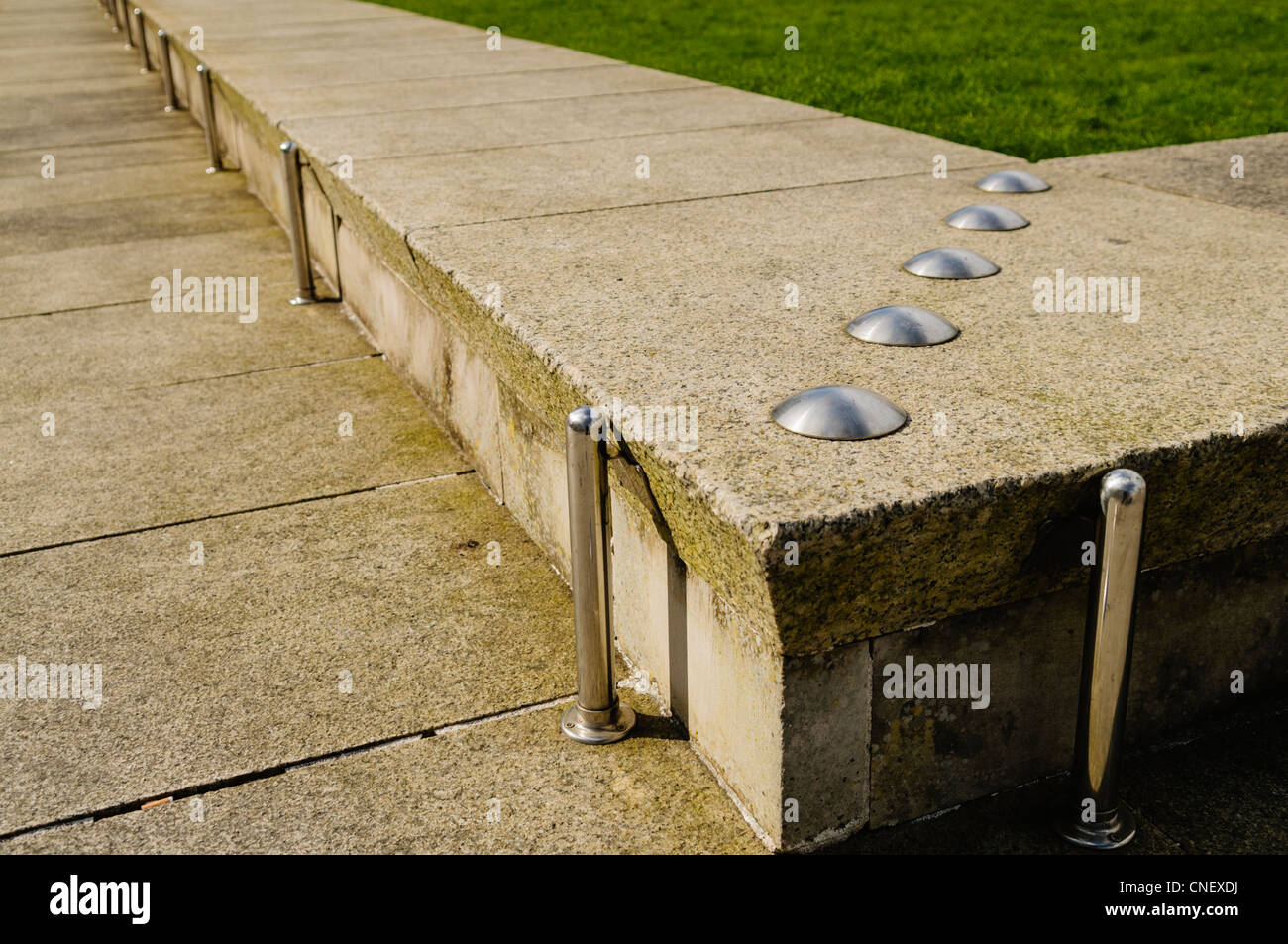 Anti-skateboarding Geräte installiert auf einer niedrigen Steinmauer Stockfoto