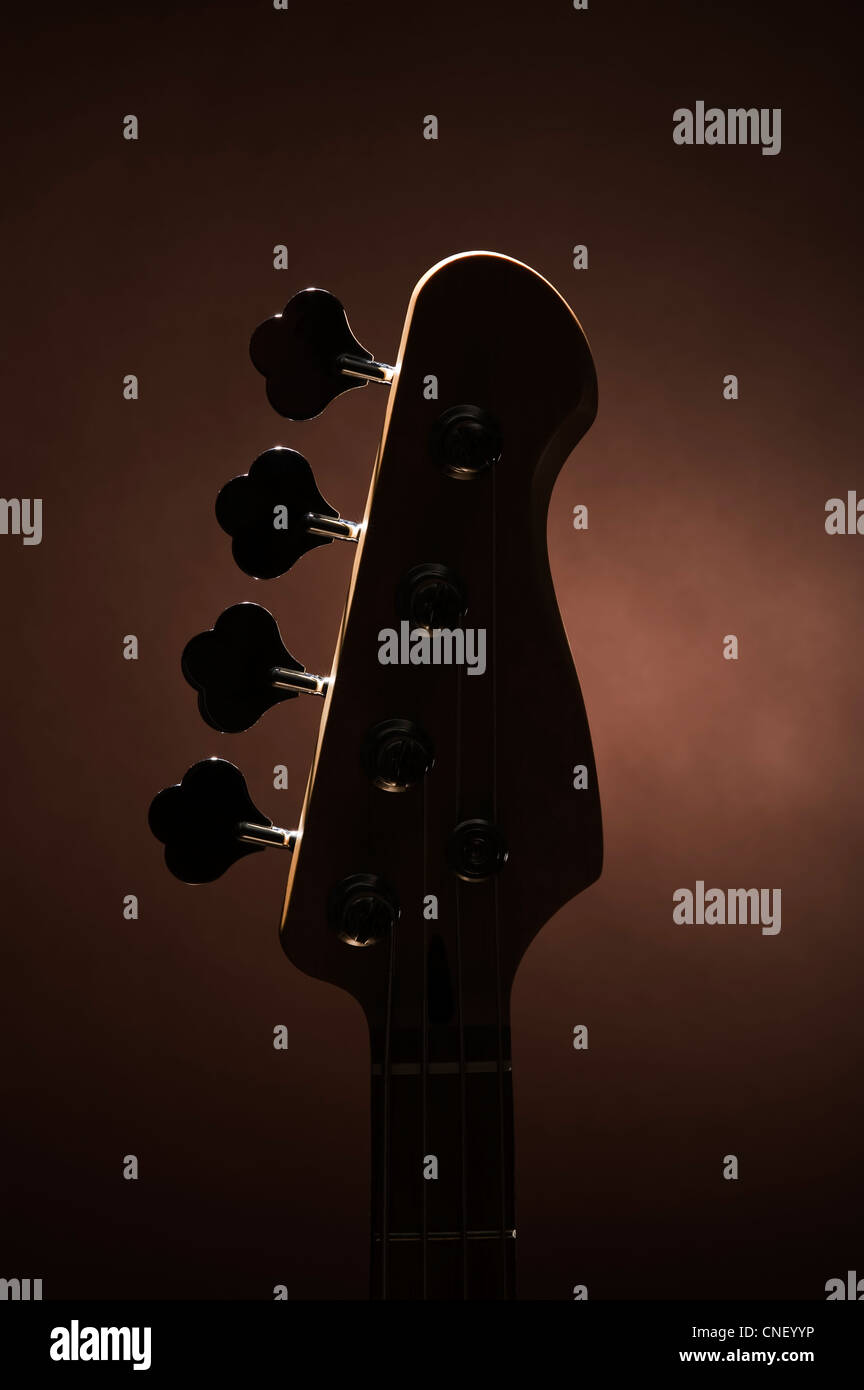 Silhouette eines Bass-Gitarre-Kopfes auf braun Stockfoto