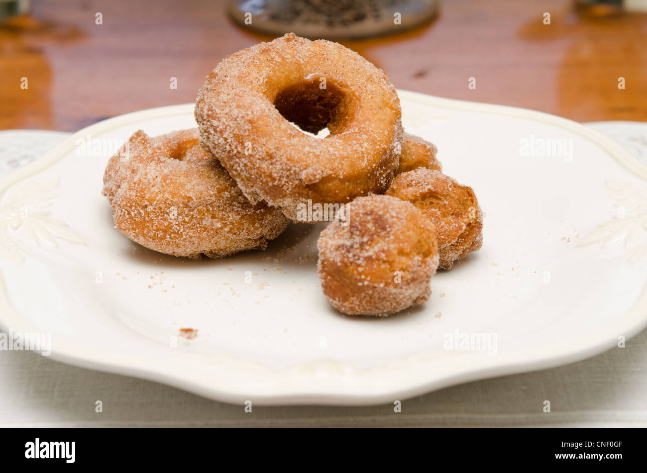 Hausgemachte gebratene Donuts und Donut-Löcher auf einem weißen Teller. Stockfoto