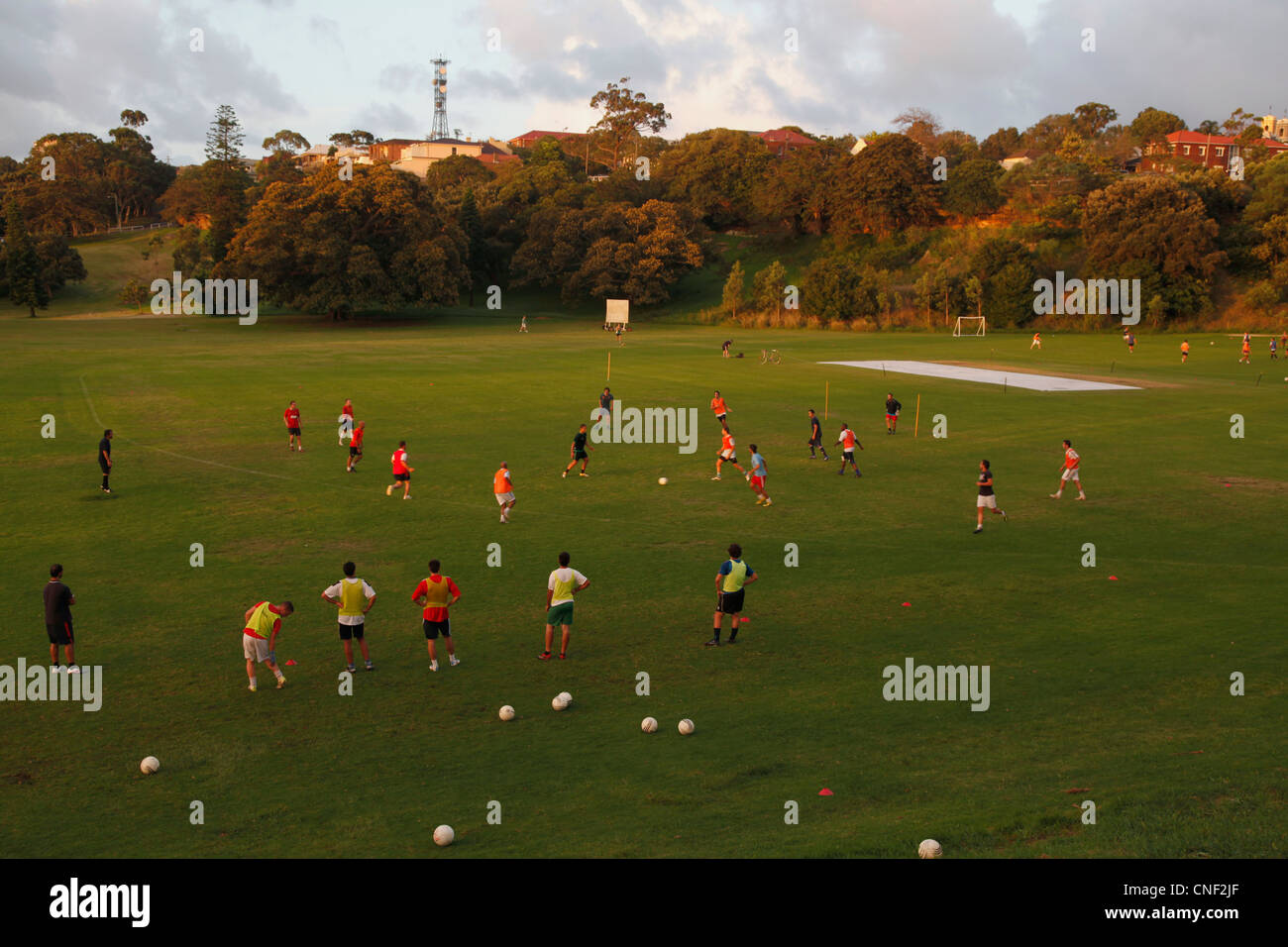 Männer und Frauen spielen Fußball in einem Park in Sydney, Australien Stockfoto