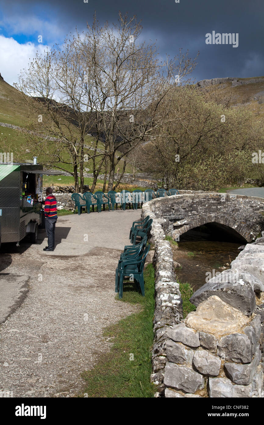 Mann, der bei einem Besuch in Malham, Malhamdale, North Yorkshire, Großbritannien Erfrischungen oder mobile Fast-Food-Caterer bei Gordale Scar kauft Stockfoto