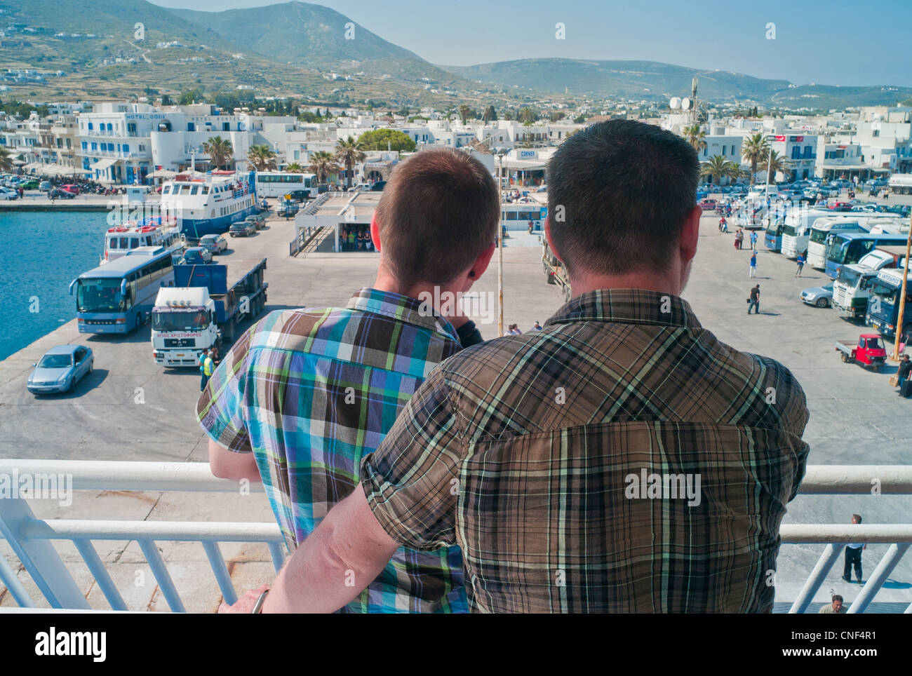 Zwei junge Männer mit Blick auf den Hafen von Paros nachmittags an einem Blue Star Ferry Reisen durch die Kykladen in Griechenland Stockfoto