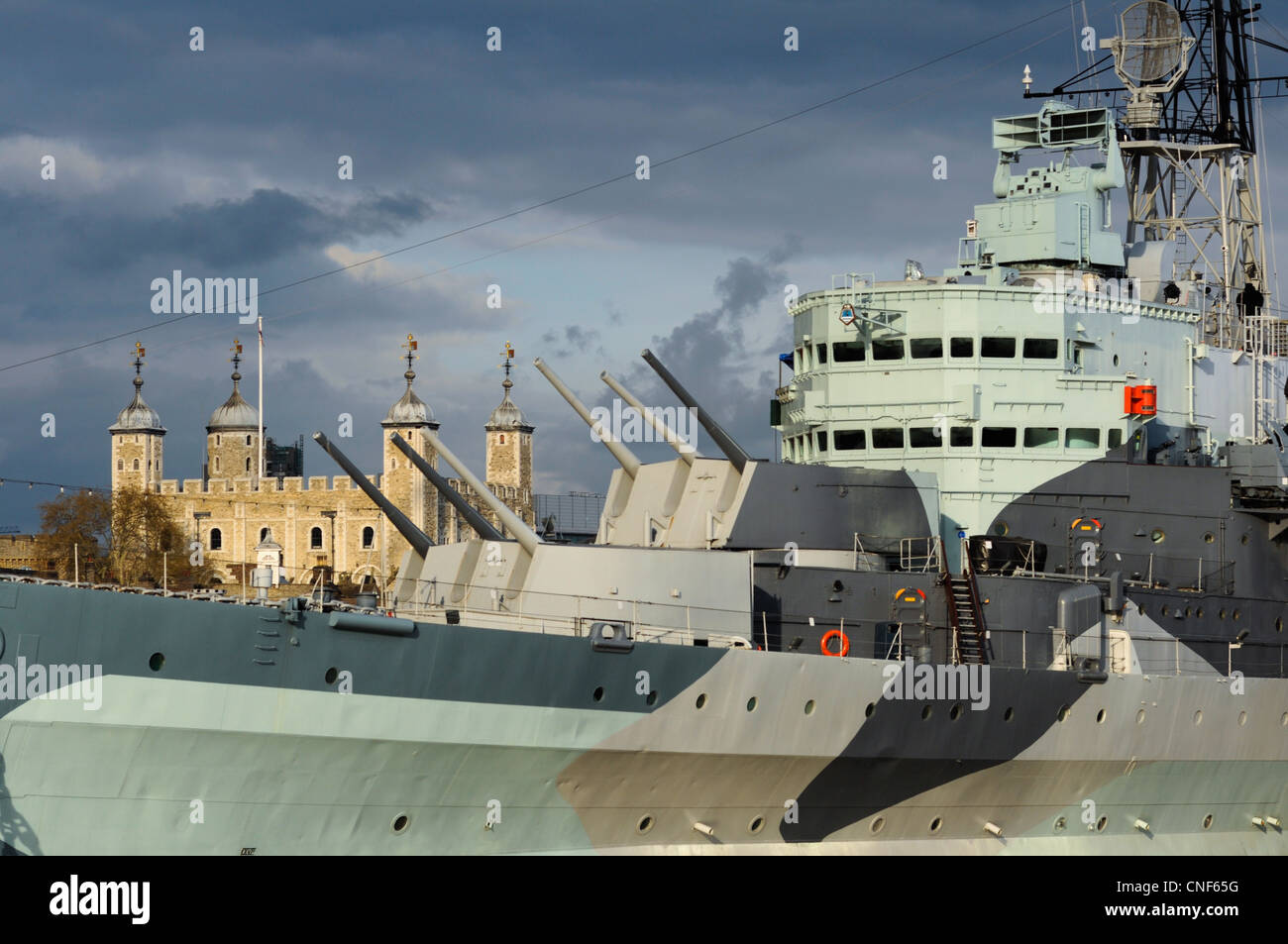 HMS Belfast mit dem Tower of London in dramatische Licht, Themse, London. VEREINIGTES KÖNIGREICH.  Mit Carl Zeiss Objektiv aufgenommen. Stockfoto