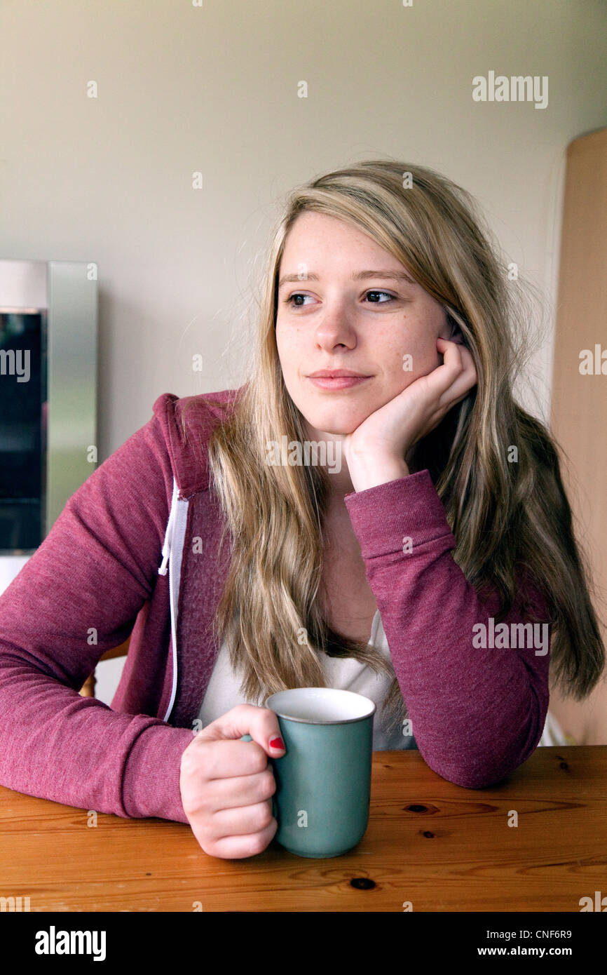 Junge attraktive blonde Teen Girl Frau denken bei einer Tasse Kaffee, UK Stockfoto