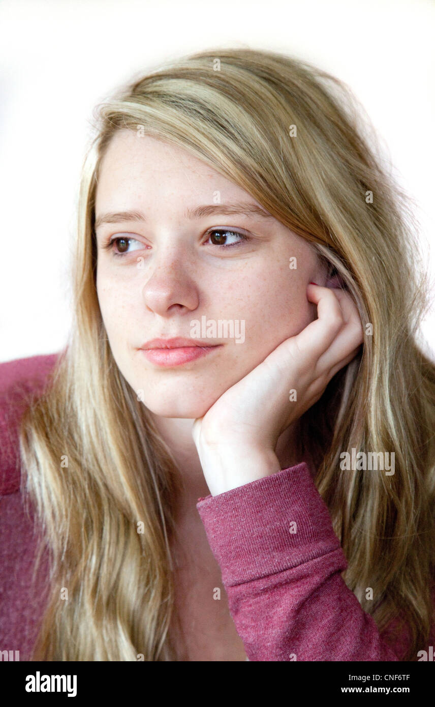 Ein Kopf und Schultern Porträt eines jungen attraktiven blonden Mädchens denken, UK Stockfoto