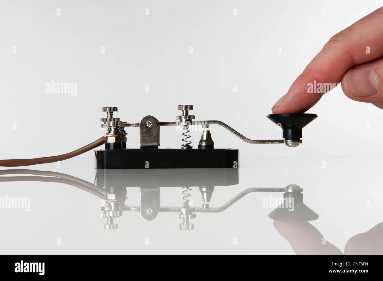 Morse-Code-Schlüssel auf einem weißen Hintergrund mit jemandem eine Nachricht senden Stockfoto