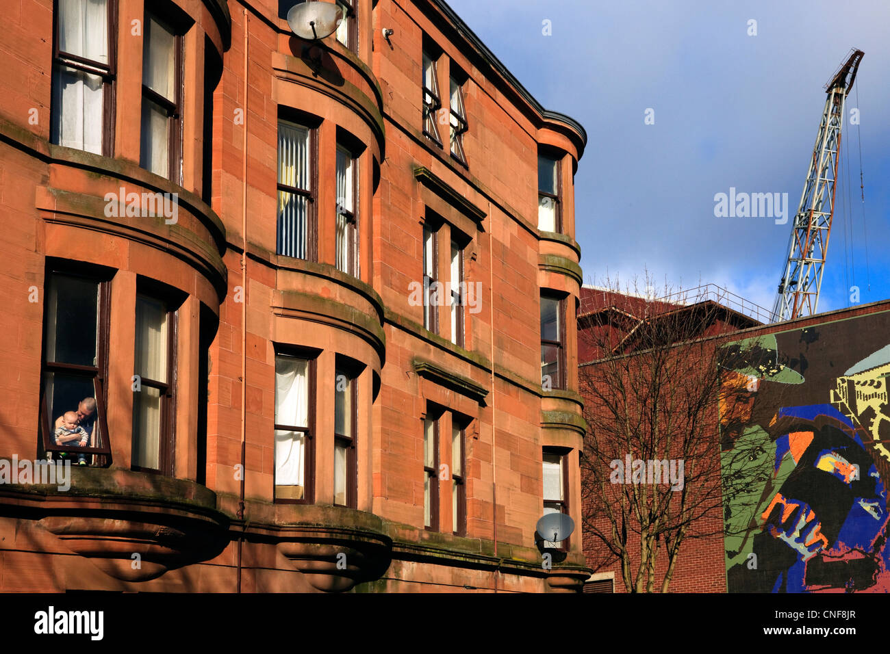 Wohnhäuser in Howat Street, Govan, Glasgow mit dem wippbar Kran der Werften im Hintergrund Stockfoto