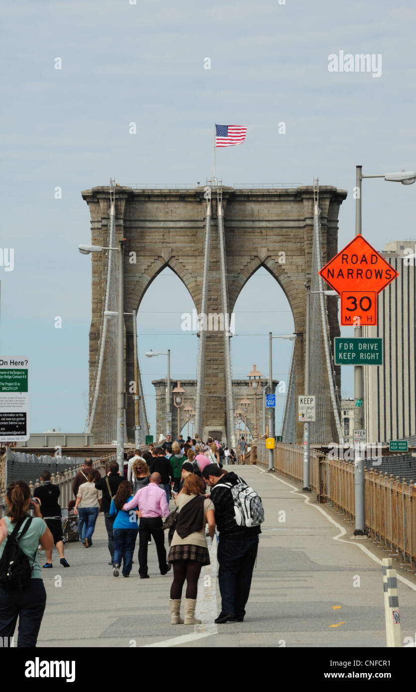 Herbst Porträt Menschen gehen, paar stehend, amerikanische Flagge, Turm oben, Brooklyn Bridge Fußgängerweg, NewYork Stockfoto