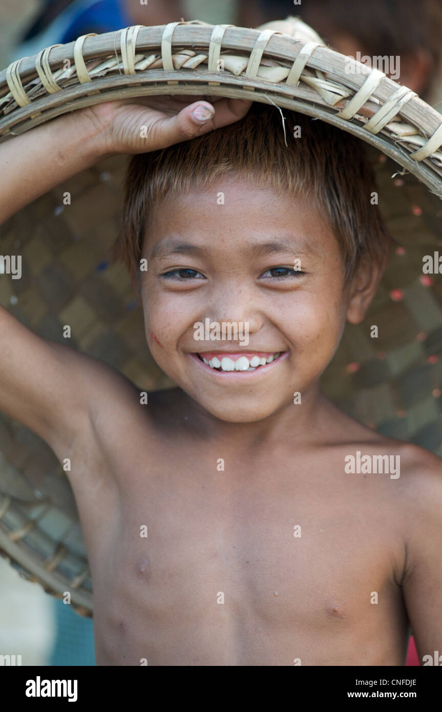 Burmesische Kind mit Rattan-Korb auf Kopf arbeitet an der Waterfront, Mandalay, Birma. Myanmar Stockfoto