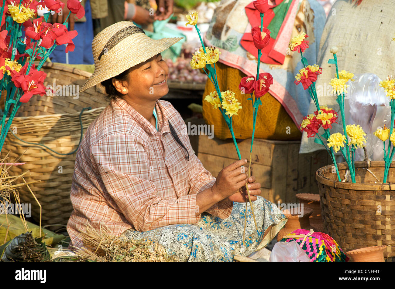 Burmesische Frau verkaufen handgefertigte geflochten Fans und künstliche Blumen. Hsipaw Markt, Burma Stockfoto