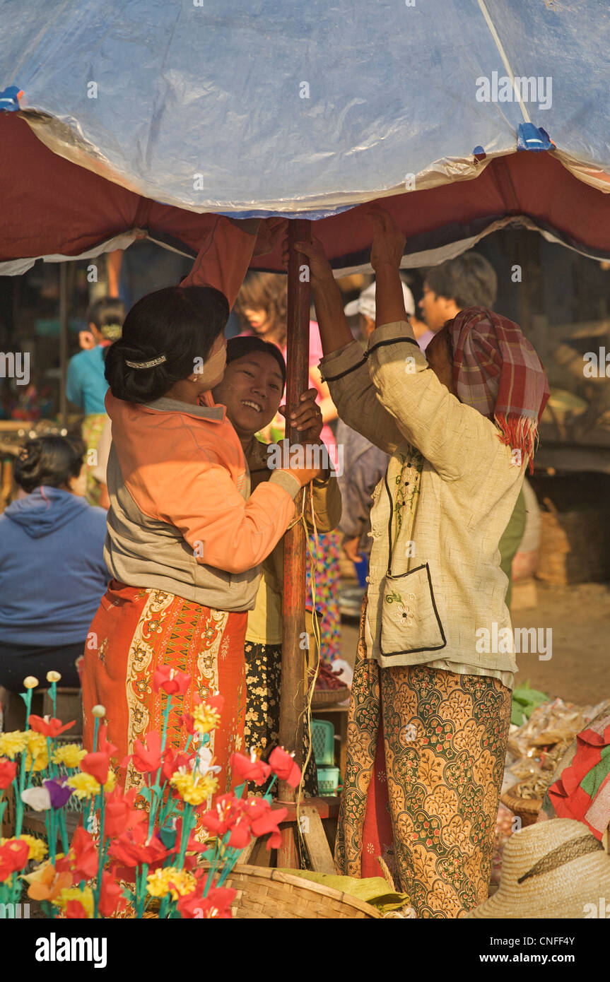 Birmanischen Frauen errichten einen Sonnenschirm in einem Stall, Hsipaw Markt, Burma Stockfoto