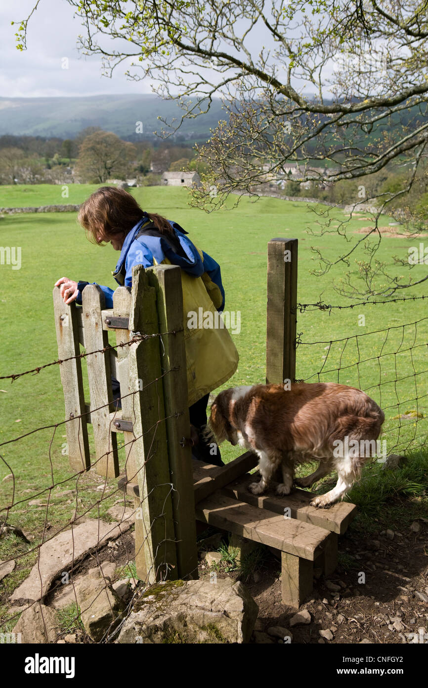 Wanderer mit Hund überqueren einen Stil in der North Yorkshire National Park, über West Burton, Wensleydale, UK Stockfoto