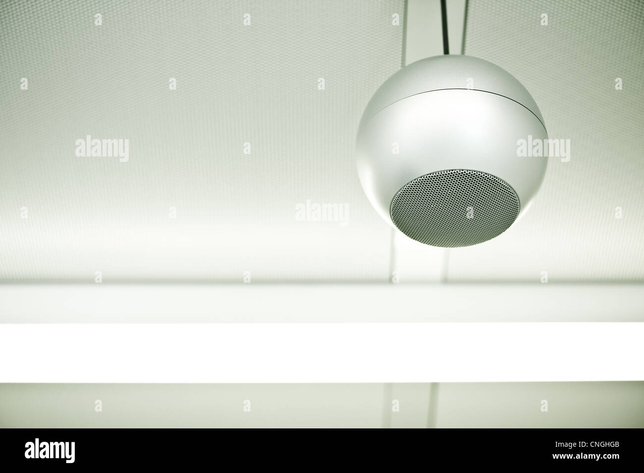 Eine einzelne runde Lautsprecher hängt von der Decke in ein steriles,  weißes Zimmer Stockfotografie - Alamy