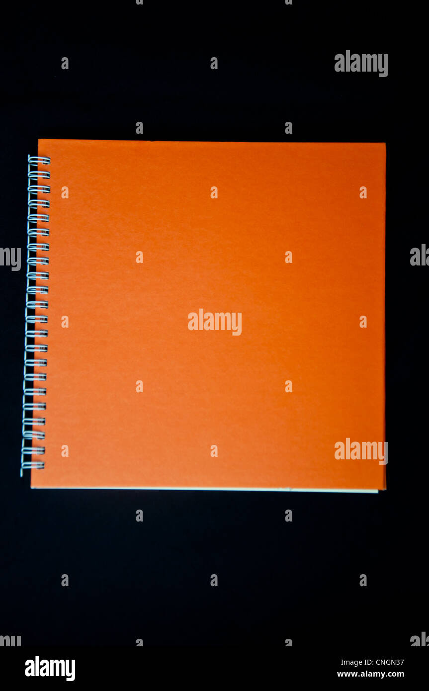Orange Notebook auf schwarzem Hintergrund Stockfoto